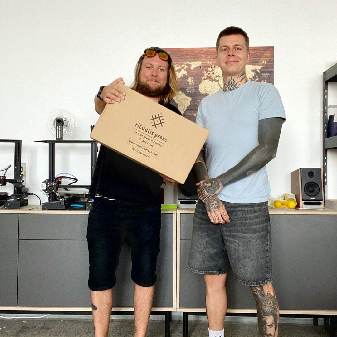 Ritualis Press founders Marek and David holding box with linocut press